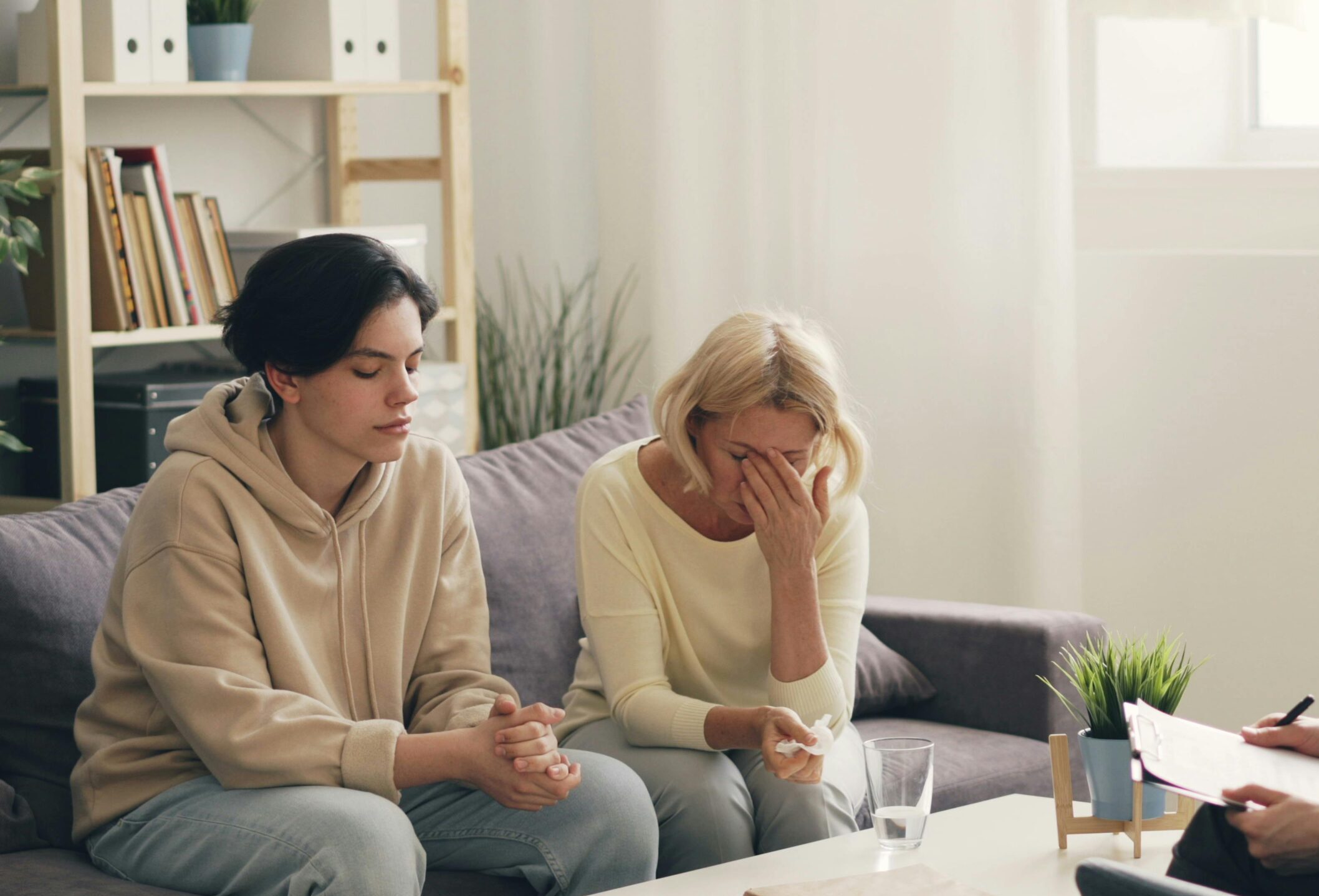 Emotional family therapy session with a therapist indoors, conveying connection and support.